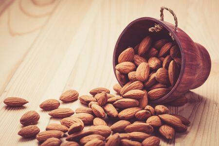 Almonds pour from wood Cupの写真素材