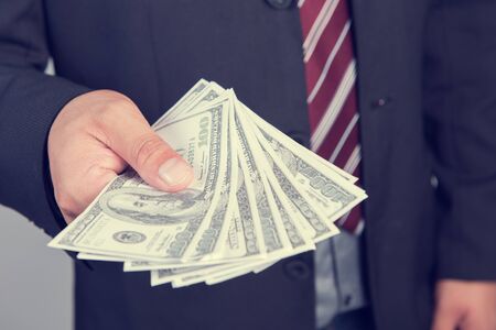 Businessman with money in hand, US dollar (USD) bills - investment, success and profitable business...