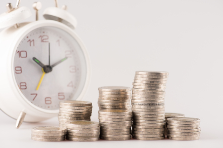 Close up of stacking gold coins with alarm clock ,Business Finance and Money concept,Save money for prepare in the future.の写真素材