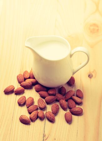 Almond milk in a jar with almond on a wooden tableの写真素材