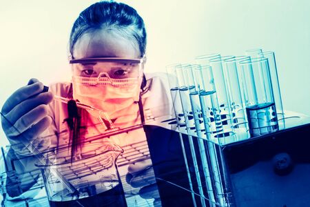 female medical or scientific researcher or woman doctor looking at a test tube of clear solution in a laboratoryの写真素材