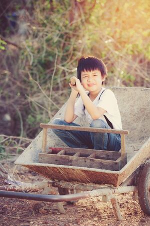 Cute Asian boy playing on a cartの写真素材