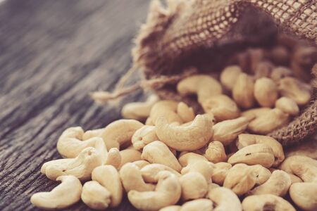 raw cashew nuts pour from sackの写真素材