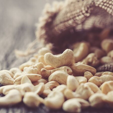 raw cashew nuts pour from sackの写真素材