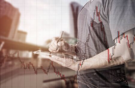 Double exposure of businessman using digital tablet with city landscape blurred background.with...