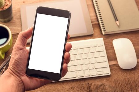 hand holding smart phone with blank white screen top view