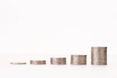 money coins arranged as a graph on white background