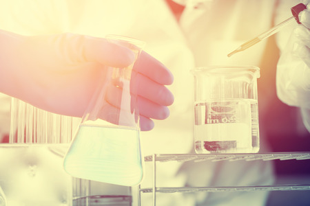 Flask in scientist hand with test tubesの写真素材
