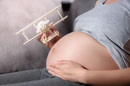 pregnant woman with model airplane on her belly,The future for children conceptの写真素材