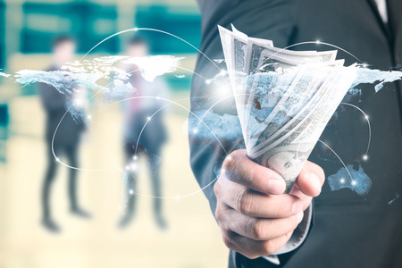 Money in Businessman hand and worldmap connection background, US dollar,investment, success and profitable business concepts.Elements of this image furnished by NASA.の写真素材