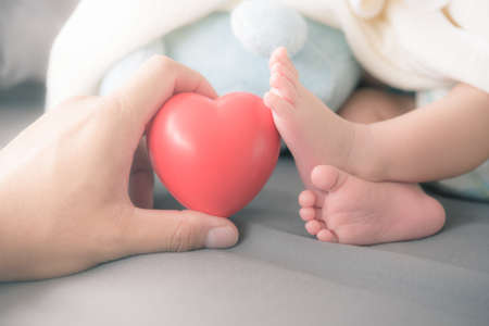 baby's feet with a red heartの写真素材