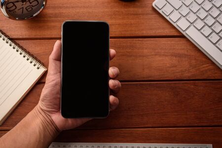 hand use smart phone with blank empty screen top viewの写真素材