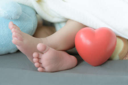 baby's feet with a red heartの写真素材