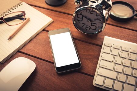Office desk with smartphone and supplies. Top view.の写真素材