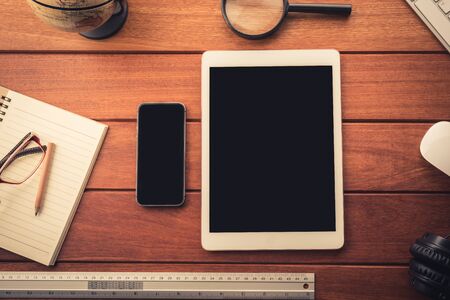 mockup tablet on wood desk. black display.keyboard and office stuff, workplace, top viewの写真素材