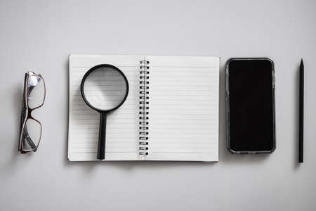 Blank notebook is on top of white office table.の写真素材