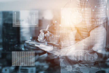 Double exposure of businessman using digital tablet with business graphの写真素材