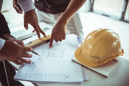 Architect man and engineer working with blueprints, engineer inspection in workplace for architectural plan, sketching a construction project , selective focus.の写真素材