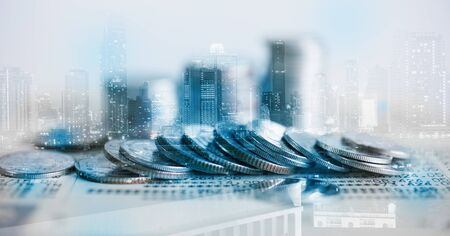 Double exposure of coins and city background for finance and banking conceptの写真素材