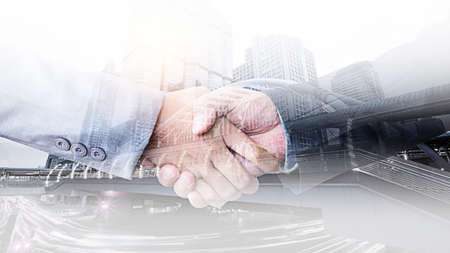 Double exposure of handshake and city scape backgroundの写真素材