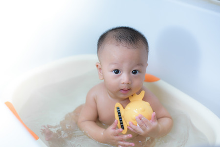 7 months cute baby boy bathing in the bath room.の写真素材