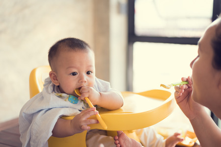 Mom is feeding baby food.の写真素材