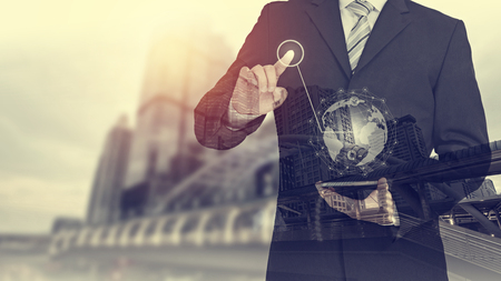 Businessman hand touching virtual button on Earth map point with network connection, international meaningの写真素材