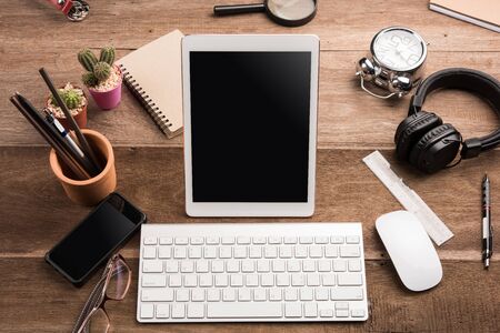 White Tablet With Blank Screen On Wooden Desk With Stationery Objectsの写真素材