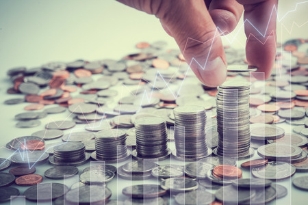 Male hand putting coins with money stack and virtual screen graph step growing growth saving money,...