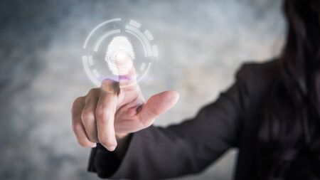 Fingerprint scan provides security access with biometrics identification; person touching; virtual; screen with finger in backgroundの写真素材