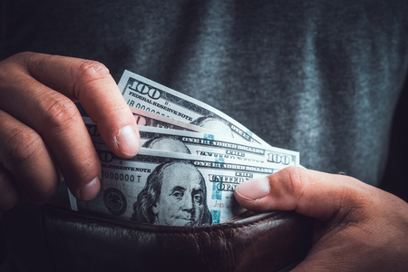 Man Hands holding US dollar bills and pocket money. Toned picture