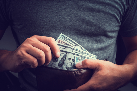 Man Hands holding US dollar bills and pocket money. Toned picture