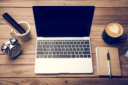 computer notebook with office tools on wood tableの写真素材