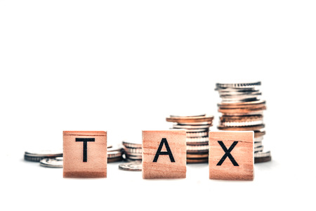 Tax concept with wooden blocks and coins on white backgroundの写真素材
