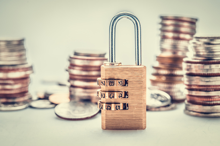 combination padlock with coin money for financial security conceptの写真素材