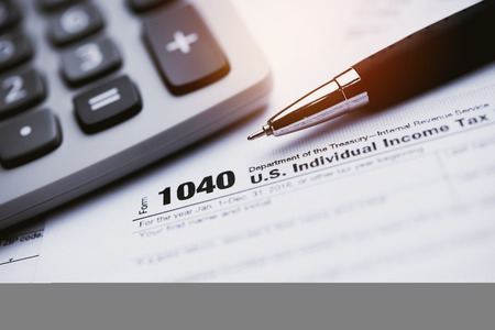 Close up a pen with Tax forms 1040の写真素材
