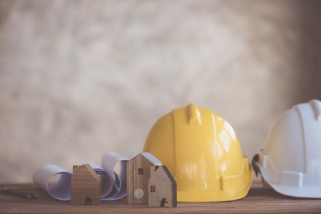 Construction house. Repair work. Drawings for building and helmet on wood table.