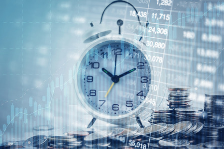Double exposure of graph, stock display and clock and rows of coins for time of finance and business concept.の写真素材