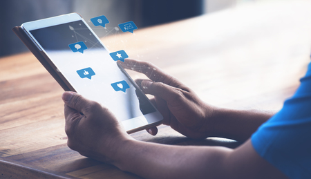 Man using the digital tablet with Social media icons.Social, media, Marketing concept. in the morningの写真素材