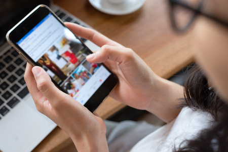 Woman hand using a smartphone in the holiday at coffee shop.