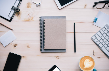 Office desk with notebooks,smartphone,glasses,pencil, on wood table background. Top view with copy space for design. Business and finance conceptの写真素材
