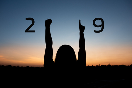 Silhouette of happy woman with New year 2019 concept on sunset background.の写真素材