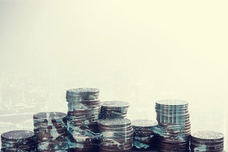 Double exposure of city and rows of coins for money, finance and business conceptの写真素材