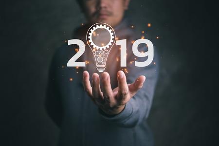 man on blurred background holding virtual screen lightbulb with a cog.new idea creative idea.Concept of idea and innovation.welcome year 2019 concept.の写真素材