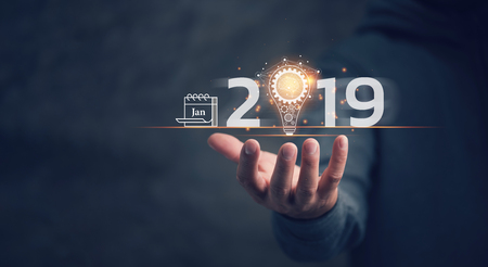 Business new year 2019. Businessman holding light bulb with icon business marketing and brain structure, innovative and software development, IoT concept. Trend, global networking and data exchangeの写真素材