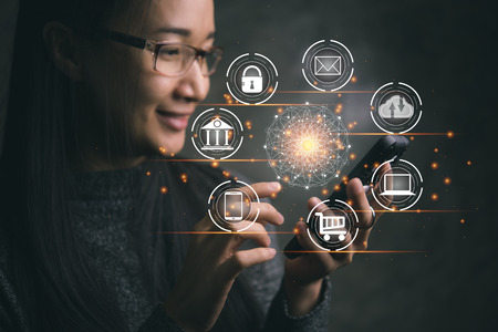 Digital marketing. Businesswoman holding smartphone wtih global circle interface payment online shopping and icon customer network connection on virtual screen. Data exchanges. Business innovation technology conceptの写真素材