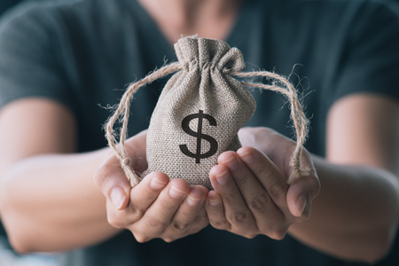 Women hand hold a money bag, a loan or saving money for future investment concept.の写真素材