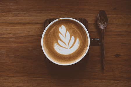 Cup of coffee latte with beautiful latte art on wood table background,topview.の写真素材