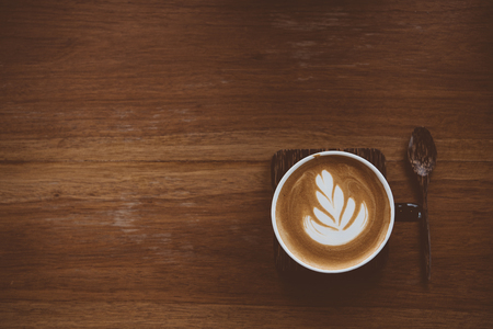 Cup of coffee latte with beautiful latte art on wood table background,topview.の写真素材