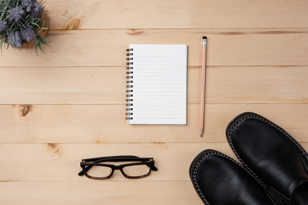 paper notebook and pencil with black Leather shoes.Top view with space for text and design.の写真素材